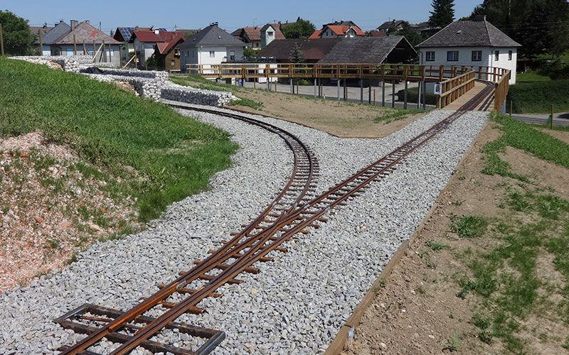 Die ca. 40 m lange Kehrschleifen-Brücke mit Stützen aus Stahl-Quadratrohr 120/120/4 mm und druckimprägnierten Kanthölzern. Im Vordergrund: Federweiche